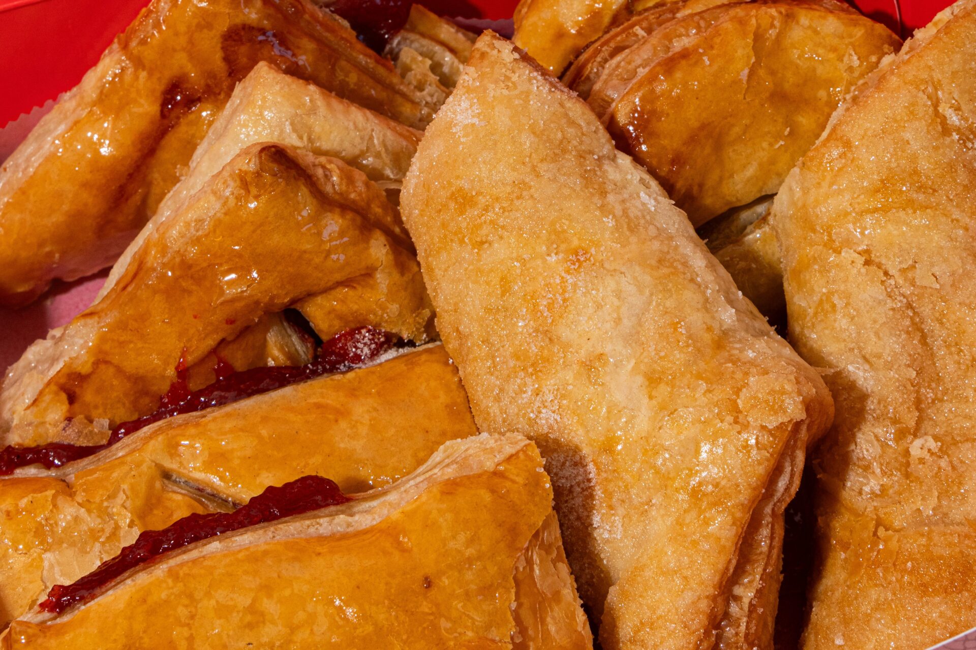 Close-up of golden-brown puff pastelitos filled at Vicky Bakery